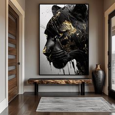 a large black and gold painting on the wall next to a bench in a room