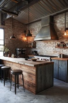 an industrial style kitchen with brick walls and wooden counter tops, bar stools, and pendant lights hanging from the ceiling