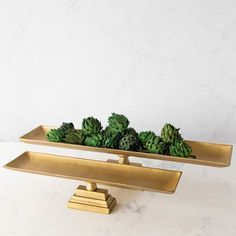 two brass trays with green plants in them