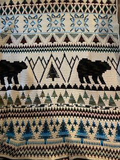 a blanket with two bears and trees on it