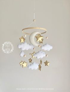 a baby crib mobile with stars and clouds hanging from it's sides in a nursery room