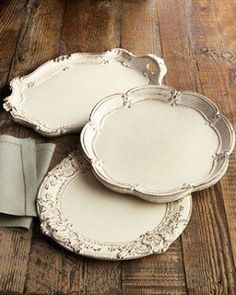 three white plates sitting on top of a wooden floor