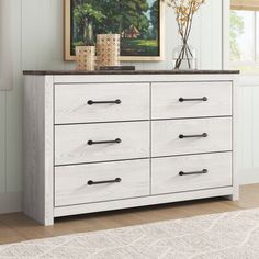 a white dresser with drawers in a room