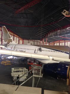 an airplane being worked on in a hangar