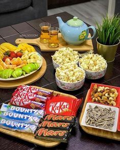 various snacks are arranged on trays on a table