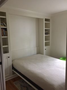 there is a bed that has built in to the wall with bookshelves behind it