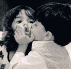 two children are kissing each other on the bed