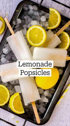 lemonade popsicles with ice and lemons on a tray next to some water