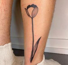 a person with a tattoo on their leg that has a tulip drawn on it