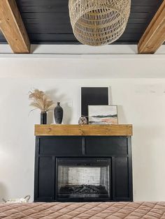 a bedroom with a bed, fireplace and wicker basket hanging over the headboard