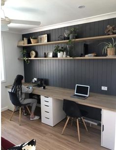 a woman sitting at a desk in front of a laptop computer on top of a wooden table