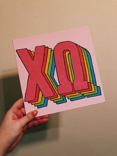 a person holding up a card with the word xo in it's center