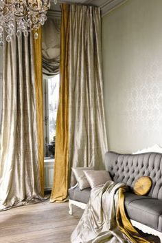 a living room filled with furniture and a chandelier hanging from the ceiling next to a window