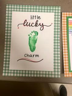 two little lucky cards with the words charm and a handprinted foot on them