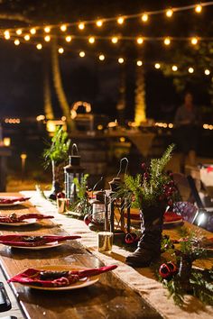 a long table is set up with plates and candles for an outdoor dinner or party