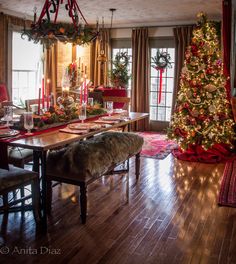 a dining room with a christmas tree in the corner and other decorations on the table