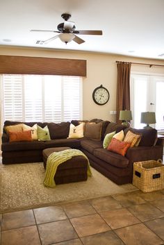 a living room filled with furniture and a large clock mounted to the wall above it