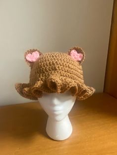 a crocheted hat with ears on top of a white mannequin head