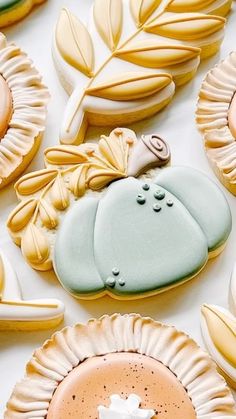 some cookies that are on top of a white tablecloth with leaves and other decorations