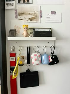 there are several key chains hanging on the wall next to pictures and other things in front of them