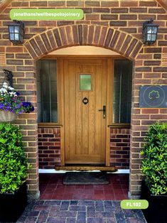 a wooden door sitting in the middle of a brick wall next to potted plants