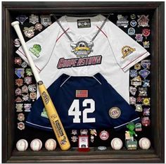 a baseball jersey and bat are in a shadow box with pins on it that include the number 42