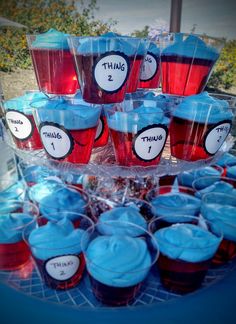 cupcakes with blue icing and red frosting are arranged on a table