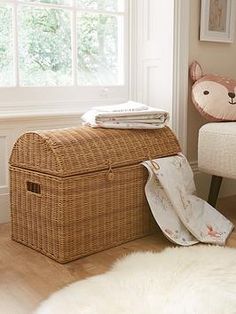 a wicker basket sitting on the floor next to a window