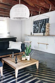 a living room filled with furniture and a wooden table in front of a black couch