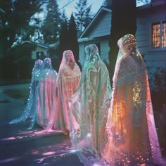 three illuminated statues in front of a house