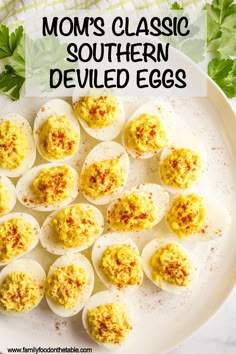 deviled eggs on a white plate with parsley