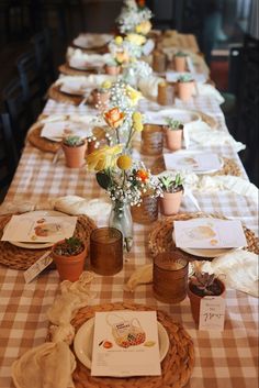 a long table is set with flowers and cards