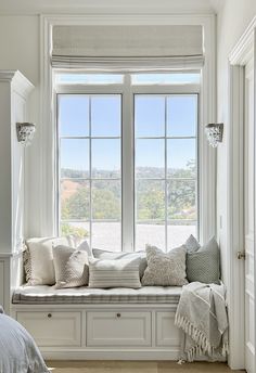 a window seat with pillows and blankets on it