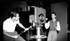 two men are working on a machine in a factory