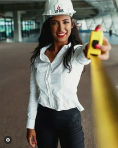 a woman wearing a hard hat and holding a yellow object