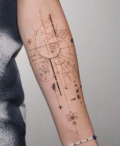 a woman's arm with a tattoo on it that has an image of the sun and stars