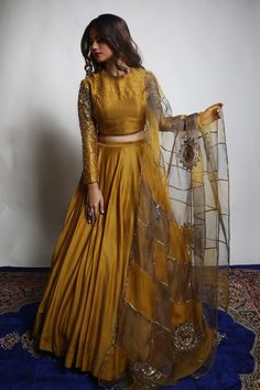 Burnt gold and grey dupion silk lehenga with heavily embroidered sleeves. Comes with a padded blouse and an organza dupatta having dual coloured patchwork, including zari and sequins hand embroidered chakra motifs .
Component: 3
Pattern: Embroidered
Type Of Work: Zari, Sequins
Neckline: V Neck
Sleeve Type: Three quarter
Fabric: Lehenga and Blouse: Dupion Silk, Dupatta : Organza 
Color: Gold
Other Details: 
Closure : Blouse : Back with Hook and Eye, Lehenga : Opening on the side with Zip and Hook Long Sleeve Lehenga, Zari Lehenga, डिजाइनर कपड़े, Lehenga And Blouse, Gold Lehenga, Simple Lehenga, Indian Outfits Lehenga, Lehenga Designs Simple, Lehnga Dress