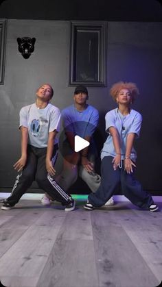 three young men are posing in front of a black wall with their hands on their hipss