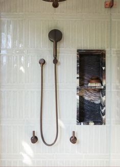 a bathroom with a shower head and hand held shower faucet in the wall