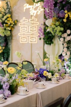 a table with flowers and tea cups on it