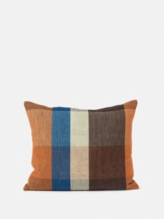 an orange, brown and blue plaid pillow on a white background with a black border