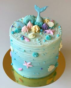 a blue and green cake with sea shells on it