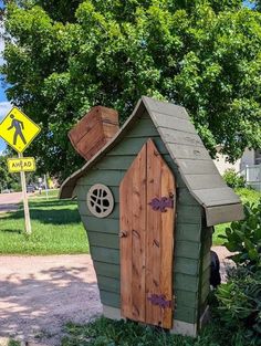 a small house made out of wood with a door and window on the outside side