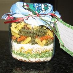 a glass jar filled with food sitting on top of a counter next to a bag