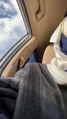 the back seat of a car with a blanket on it's head and an open window