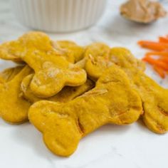 dog treats are sitting on a table next to carrots