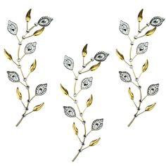 three gold and silver leaves with diamonds on them are shown in the shape of an eye