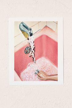 a person is washing their hands in a pink bathtub with soap and water coming from the faucet