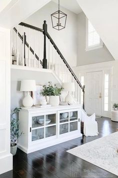 a living room filled with furniture and a staircase leading to the second floor above it