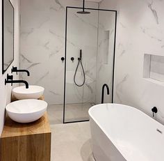 a bathroom with two sinks and a bathtub in the middle, along with a stand up shower